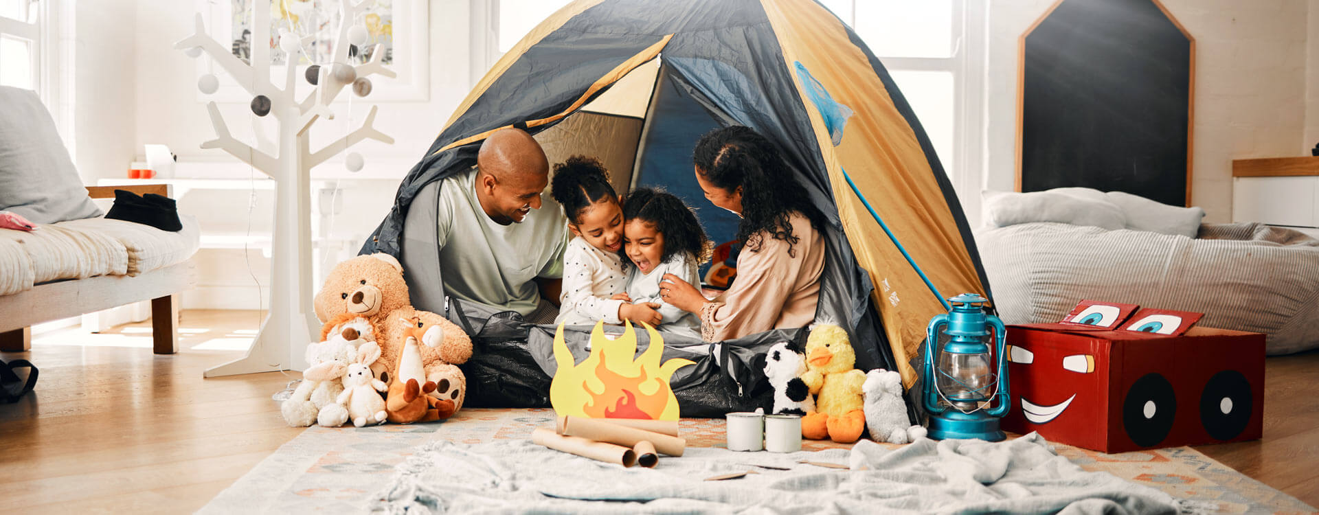 Family camping in a tent in their living room